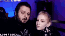 a man and a woman are looking at each other in front of a microphone