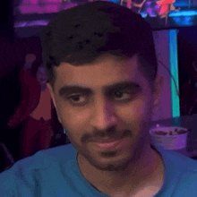 a man with a beard is wearing a blue shirt and looking at the camera