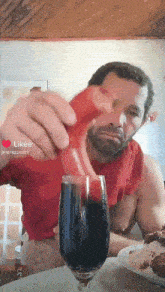a man in a red shirt is pouring something into a glass with the likee app visible