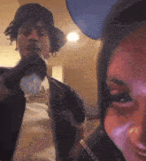 a man wearing a hat is holding a microphone in front of a woman