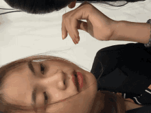 a close up of a woman 's face with her hand on her head