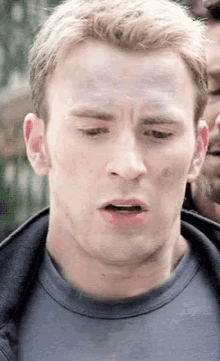 a close up of a man 's face with a gray shirt