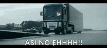 a truck is driving down a road next to a race car with the words " asi no ehhhh " written on the bottom .