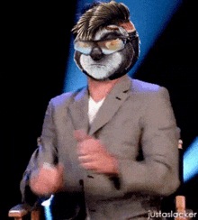 a man wearing a suit has a sloth mask on his head