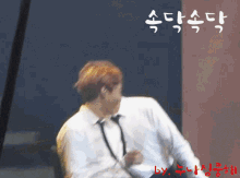 a man in a white shirt and tie is dancing in front of a sign that says ' by '