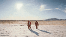 two men walking in the snow with imgflip.com written below them