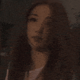 a woman with long hair is holding a white cup in her hand .