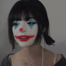 a woman with a clown makeup on her face is wearing headphones