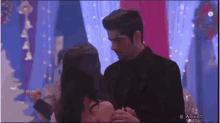 a man and a woman are dancing together in a room with a blue background .