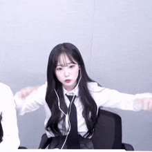 a girl with long black hair is wearing headphones and a tie