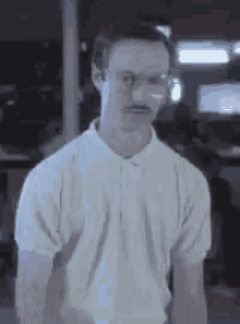 a man with glasses and a mustache is wearing a white polo shirt and looking at the camera .