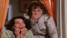 two women covering their mouths with their hands