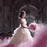 a woman in a wedding dress holding a bouquet of flowers