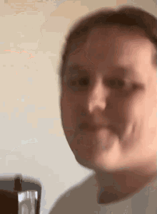 a blurry picture of a man 's face with a bottle in the background .
