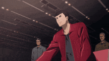 a man in a red jacket stands in a dark room with two other men