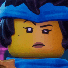 a close up of a lego character with a blue headband on