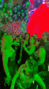 a group of women are dancing in a dark room with balloons in the background