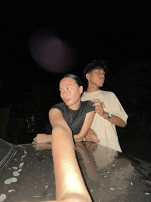 a man and a woman are posing for a picture in the dark