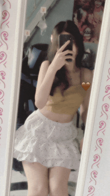 a girl taking a selfie in front of a mirror