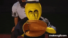 a man in a yellow costume is holding a baseball glove in front of a catcher .