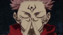 a close up of a person with their eyes closed and their hands folded in prayer .