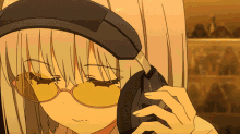 a girl wearing headphones and yellow glasses looks down