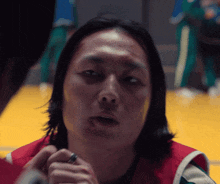 a close up of a man 's face with a ring on his finger