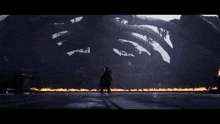 a giant monster is surrounded by fire and smoke