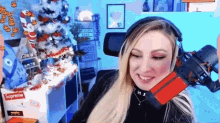 a woman wearing headphones is sitting in front of a microphone in a room with a christmas tree .