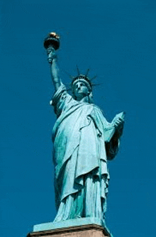 the statue of liberty is holding a torch in front of a blue sky in new york city .