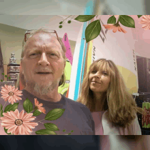 a man and a woman are posing for a picture in front of a surfboard that says naish