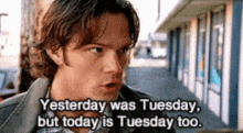a man is standing in front of a building and saying yesterday was tuesday , but today is tuesday too .