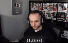 a man wearing headphones is sitting in front of a shelf of funko pop figures