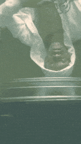a man in a white shirt is upside down on a table