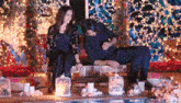 a man and a woman are sitting on a bench with candles in front of them