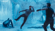 two men are fighting in a cave with a toms 2005 logo