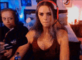 a woman wearing headphones is making a funny face in front of a microphone .