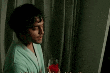 a man in a robe is holding a glass of wine
