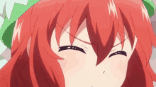 a close up of a girl with red hair and a green hat making a funny face .