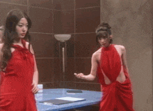 a woman in a red dress looks at the camera