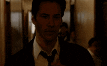 a man in a suit and tie smoking a cigarette in a hallway
