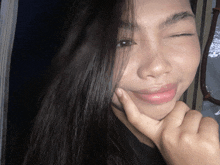 a close up of a woman 's face with a hand on her chin