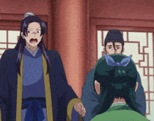 a man in a blue robe is standing next to a woman in a green dress