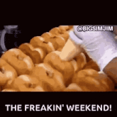 a bunch of donuts are being made in a bakery and the caption says the freakin ' weekend