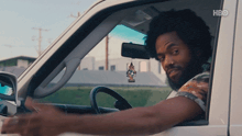 a man is driving a car with hbo written on the bottom right