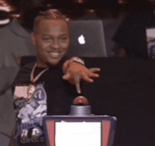 a man is pressing a button in front of an apple computer