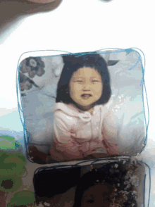 a picture of a little girl in a pink sweatshirt