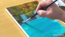 a person is painting a waterfall on a piece of paper with a brush