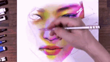 a person is drawing a woman 's face with a marker