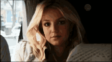 a blonde woman is sitting in a car reading a book